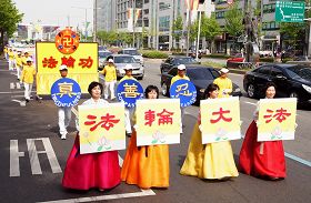 五月八日韩国法轮大法学会在首尔奥林匹克公园举行集会和游行，很多民众对游行队伍表示出好奇和关注。