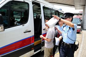 涉嫌在红磡火车站指使大陆小学生进行破坏的一名男子被警方拘留，带上警车。