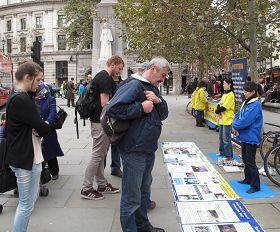 '法轮功学员在伦敦圣马丁广场揭露中共活摘法轮功学员器官罪行，吸引众多民众驻足了解真相。'