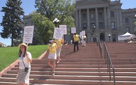 法轮功学员手举真相板从州政府阶梯广场出发开始反迫害步行活动。