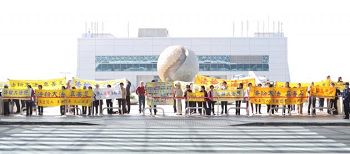 法轮功学员在机场外抗议陈德铭，要求中共停止迫害法轮功