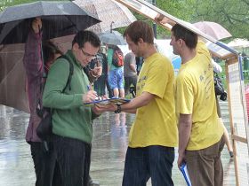 '游客在雨中签名反对中共活摘法轮功学员器官'