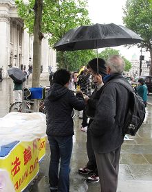 图4：法轮功学员继续冒雨征集支持反迫害签名。