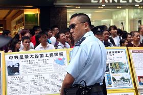 '图2：警方封锁整条街道，阻止涌上街头的香港市民接近法轮功真相点。'