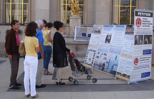 巴黎人权广场上，民众阅读展板，了解法轮功真相
