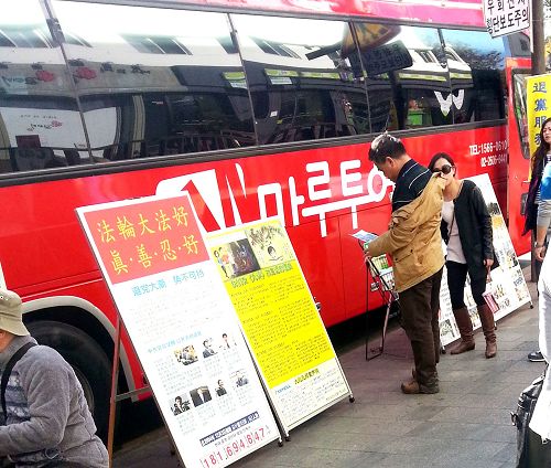 在韩国首尔景点，旅游团的巴士旁的真相展板