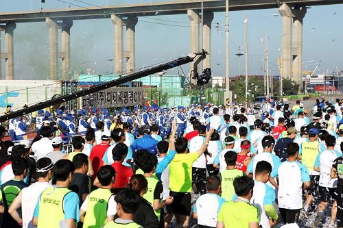 在“二零一四平泽港马拉松大会”上，在马拉松起跑线上，天国乐团演奏雄壮乐曲。