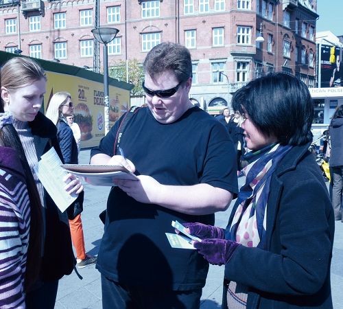 丹麦哥本哈根市政厅广场，游客签名谴责中共迫害法轮功