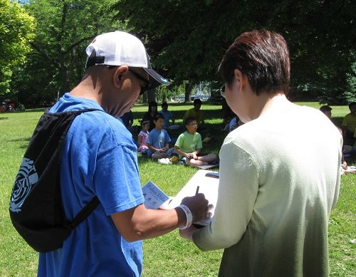 图2，游客在反活摘器官征签表上签名