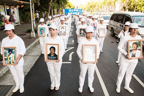 学员衣着净白素服，手捧被迫害致死的大陆法轮功学员照片，圣洁静肃行进