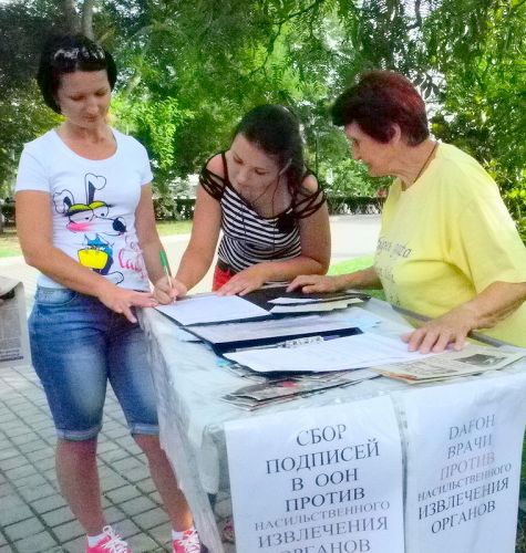 克里米亚自治共和国的法轮功学员在赛瓦斯堡市中心公园，举行讲真相、反迫害征签活动。民众在了解真相后，纷纷签名反对中共活摘暴行。