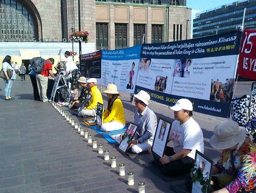 图1：法轮功学员在赫尔辛基火车站广场举办烛光悼念活动