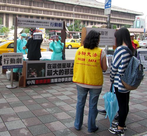 图1：台北法轮功学员在台北车站商圈以模拟演示行动剧，揭露中共暴行