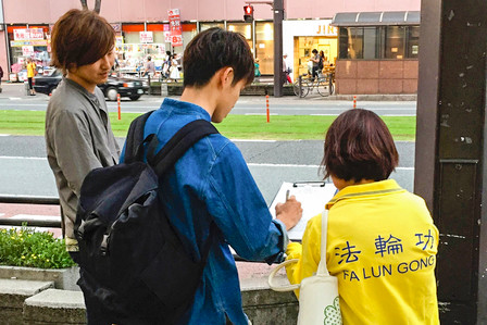 图：日本熊本县街头的民众署名声援诉江