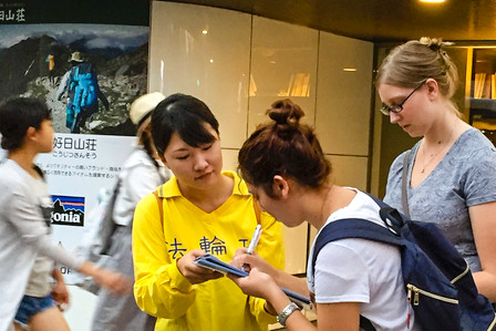图：来到熊本县的外国游客署名声援诉江