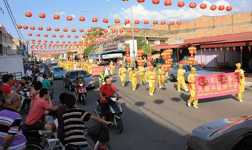 法轮功学员来到了彭亨州直凉举行新年游行，吸引了许多民众追随观看。