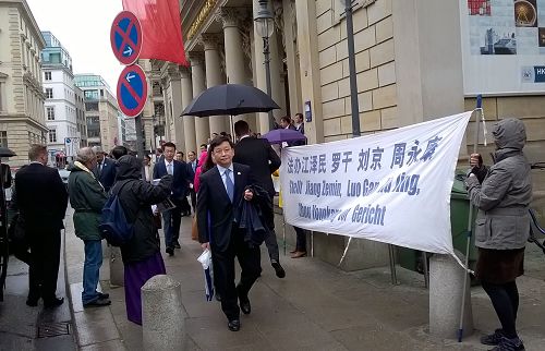 中国代表团在汉堡商会中心从和平抗议的法轮功学员面前经过