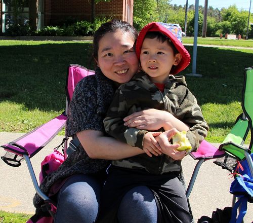 台湾的张太太带着儿子Arthur观看游行，儿子远远看到“法轮大法”的横幅，就兴奋的抓住妈妈说：“妈妈快看，法轮功来了。”