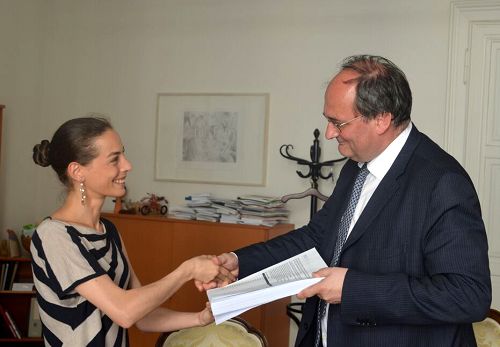 图3：“为受威胁人民协会（GFBV）代表 Nadine Papa （左）向人权专员Doujak博士（右）递交一年来的征签副本。