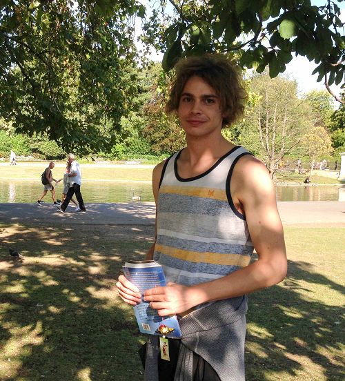 二零一五年八月二十二日，罗马青年麦克在英国伦敦摄政公园法轮功炼功点第一次学炼法轮功，手拿意大利版的《法轮功》和法轮功学员制作的手工莲花，高兴地笑了