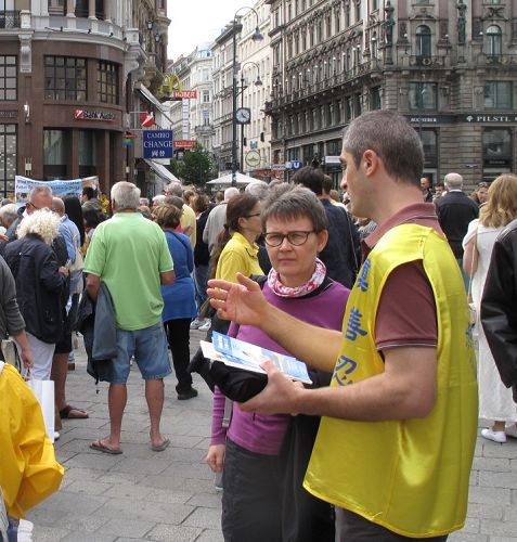 图：2015年9月19日，在维也纳斯特凡大教堂前广场，安德烈向一位信奉天主教的女士耐心讲真相