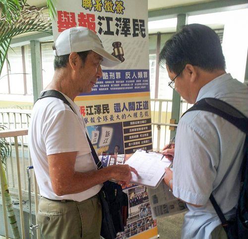 法轮功学员向签名举报江泽民的香港市民讲真相。