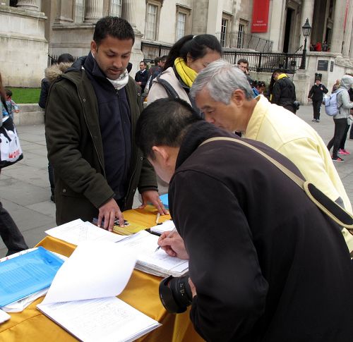 图8：这位华人来自中国大陆，已在英国生活多年，他在反活摘、声援起诉江泽民的文件上痛快签自己的名字。