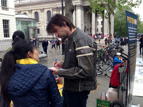 图8：来自美国拉斯维加斯的迈克在伦敦圣马丁广场第一次了解法轮功真相，他在举报江泽民的征签表上签名