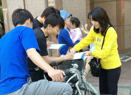图1-2：日本法轮功学员在福冈天神征集声援起诉迫害元凶江泽民的签名。许多民众签名后，并对法轮功学员说：我们支持你们。