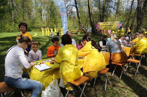 图10：莫斯科库斯明克公园里欢庆法轮大法日的活动中，小朋友学叠纸莲花