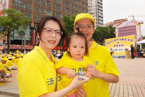 图9：韦志龙带着妻子及一岁多的女儿参加世界法轮大法日活动。