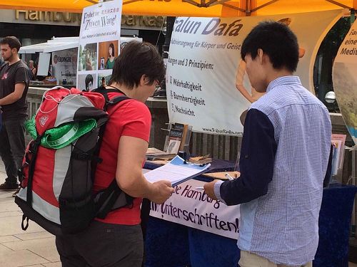 '图2～4：汉堡法轮功学员在市中心举办信息日活动中，很多民众停下来签名支持法轮功'