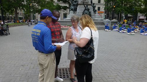 '图2：蒙特利尔法轮功学员在Philips Square广场举行了征集签名的活动'