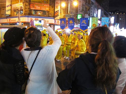 图4：民众与游客纷纷拍摄法轮功学员组成的闪亮队伍。