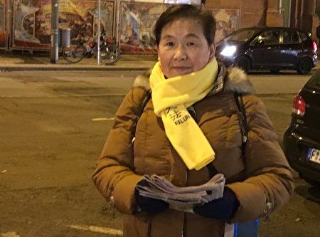 '图4：法轮功学员文女士在法兰克福街头给中国游客发关于法轮功的真相报纸。'