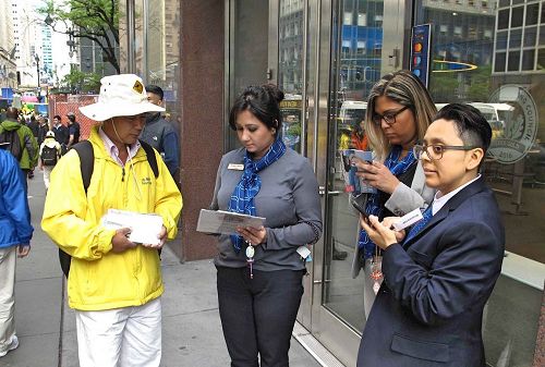'图11：几位银行职员站在店门前观看游行，了解真相后签名反对中共活摘法轮功学员器官。'