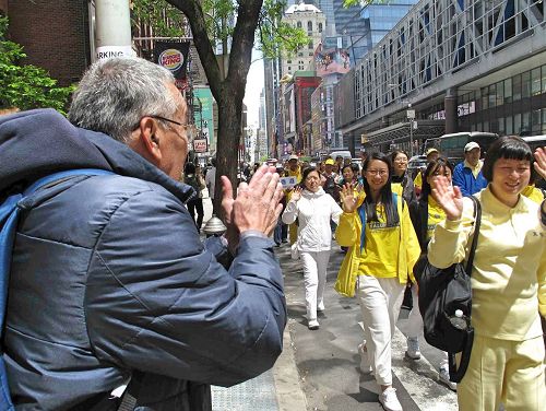 '图16：一位拉美裔老人在路边为法轮功学员盛大游行的成功举行鼓掌喝彩。'