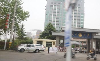 洪焕芹的两个女儿在文登区公安局门口打出“警察私闯民宅绑架”的横幅