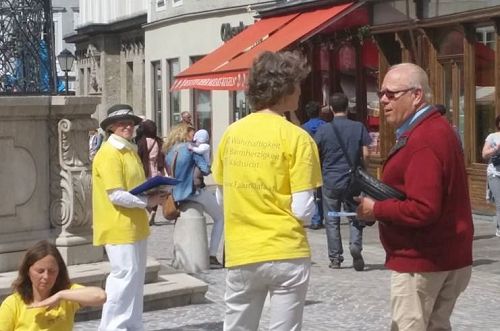 '图3，法轮功学员在萨尔斯堡市中心老城向路人讲真相'
