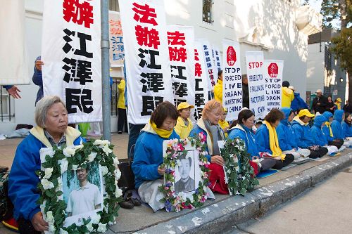 '图10：韩女士手捧被中共迫害致死的儿子叶浩的遗照，抗议中共的迫害'