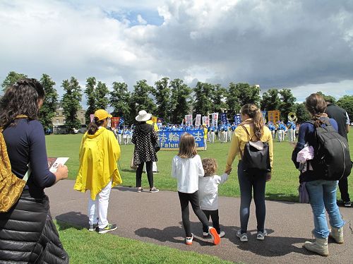 '图1：在剑桥帕克公园，法轮功学员的游行队伍开始前，天国乐团的排练吸引了民众'
