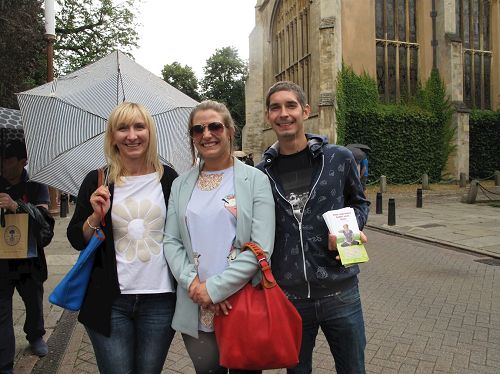 '图6：波兰女士和家人遇到正在走过剑桥大学古老建筑群的法轮功和天国乐团的游行队伍'