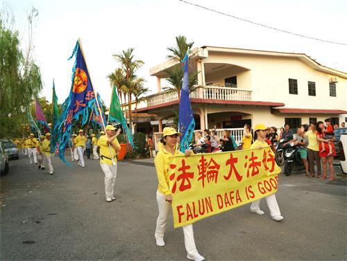 '图5～8：戊戌年大年初九（2月24日），马来西亚法轮功学员来到雪兰莪州丹绒士拔（Tanjung Sepat）举行了第二场新年游行，向当地民众拜年、送祝福，广获各族民众的欢迎。'