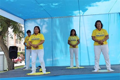 '图1～3：秘鲁法轮功学员应马格达莱纳区政府邀请参加中老年健康展。图为，法轮功学员在健康展中心舞台介绍和演示法轮功功法。'