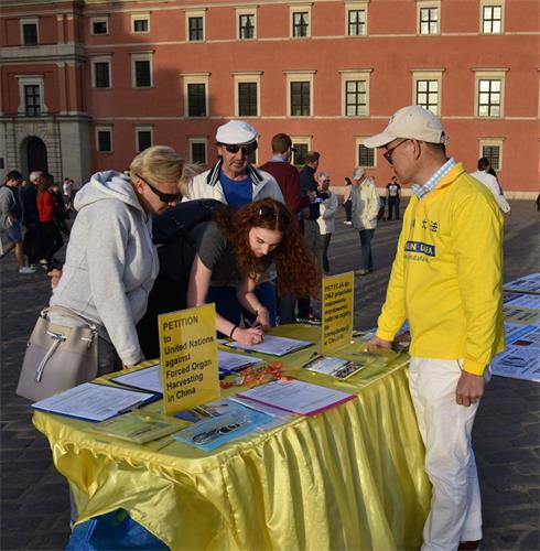 '图4～5：华沙古城广场众多游客签名反对中共活摘器官的邪恶行径'
