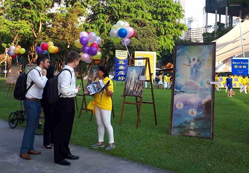 图3：新加坡芳林公园里，路人驻足听法轮功学员讲真相
