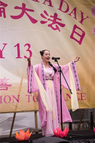 '图14：二零一八年五月十日，法轮功学员陈瑶在庆祝“第十九届世界法轮大法日”上表演女声独唱。'