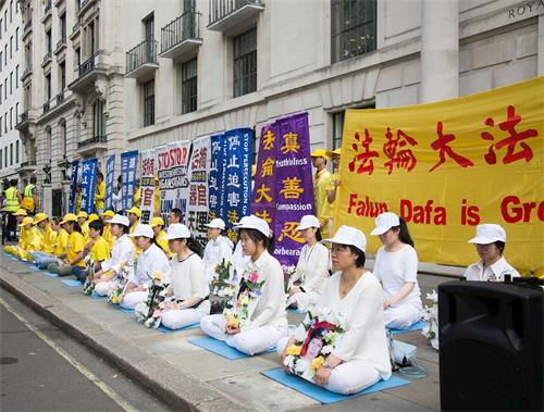 '图1～2：二零一八年七月二十一日上午，英国法轮功学员在伦敦中使馆前和平抗议，呼吁共同制止迫害。'