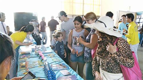 '图3～4：二零一八年九月二十二日，法轮功学员在第十七届“尔湾全球村文化节”设立了展位，许多民众前来了解。'