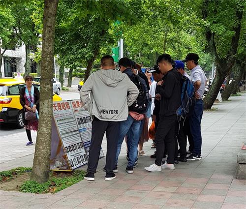 '图：法轮功学员在台北国父纪念馆的园区内的真相点吸引大陆游客了解真相'